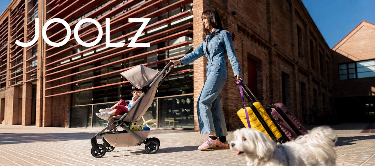 Joolz compact travel stroller with child, mother, luggage and dog in an urban setting