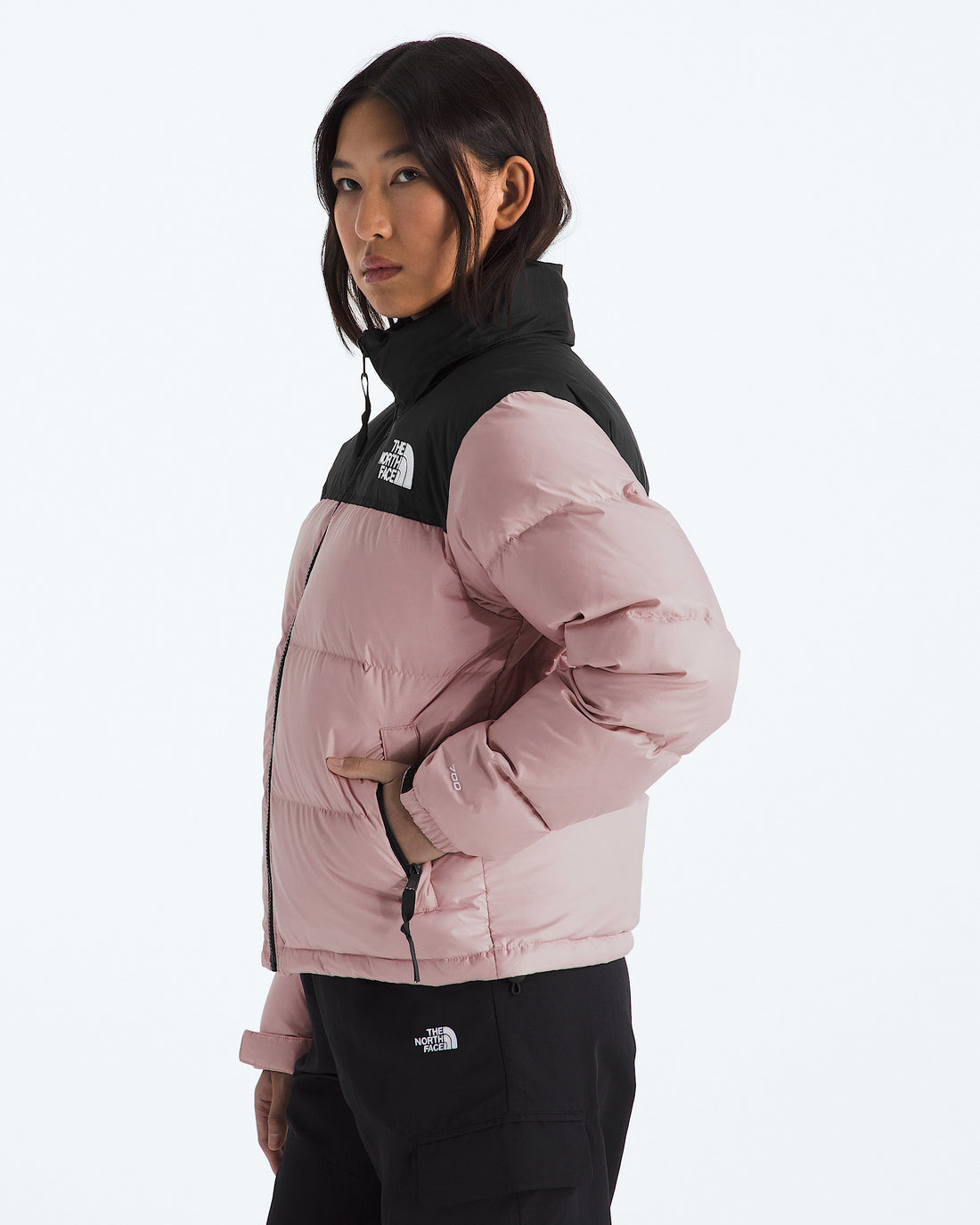 The North Face Women’s 1996 Retro Nuptse Jacket in Metal Pink/TNF Black, three-quarter model view