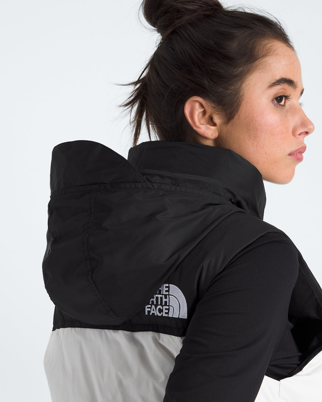 The North Face Women’s 1996 Retro Nuptse Vest in White Dune and TNF Black, stowable hood detail