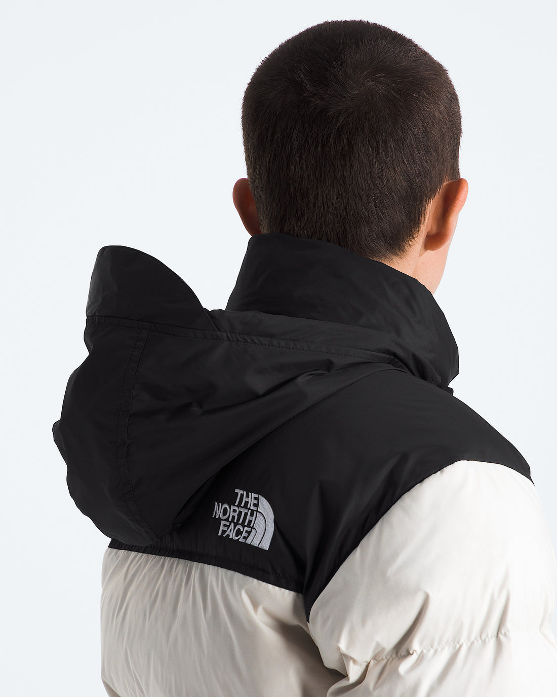The North Face Women’s 1996 Retro Nuptse Jacket in White Dune/TNF Black/Recycled Down, stowable hood detail