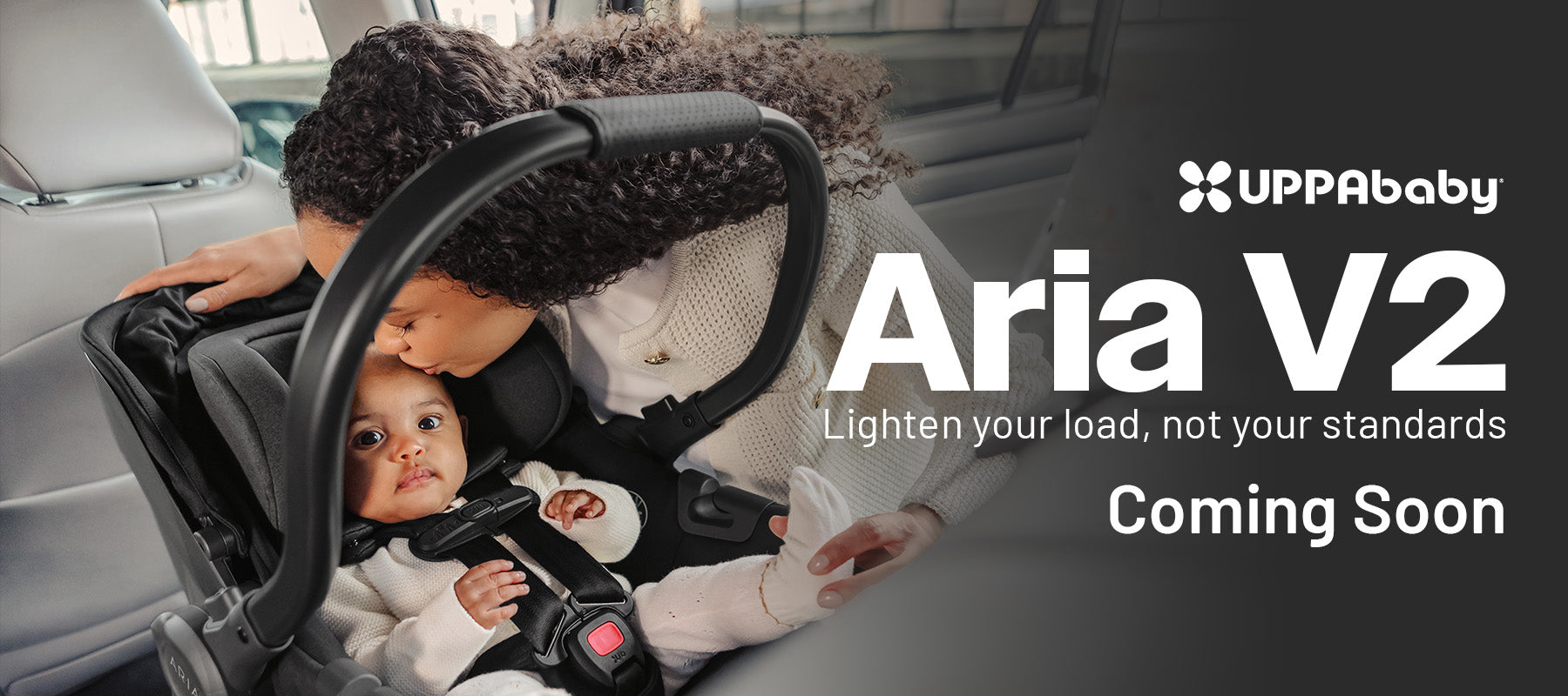 UPPAbaby Aria V2 infant car seat installed in vehicle with parent and baby lifestyle banner