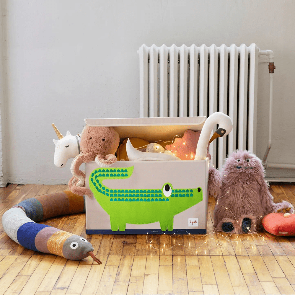 3 Sprouts Toy Chest white with neon green alligator, overflowing with plush toys and warm fairy lights.