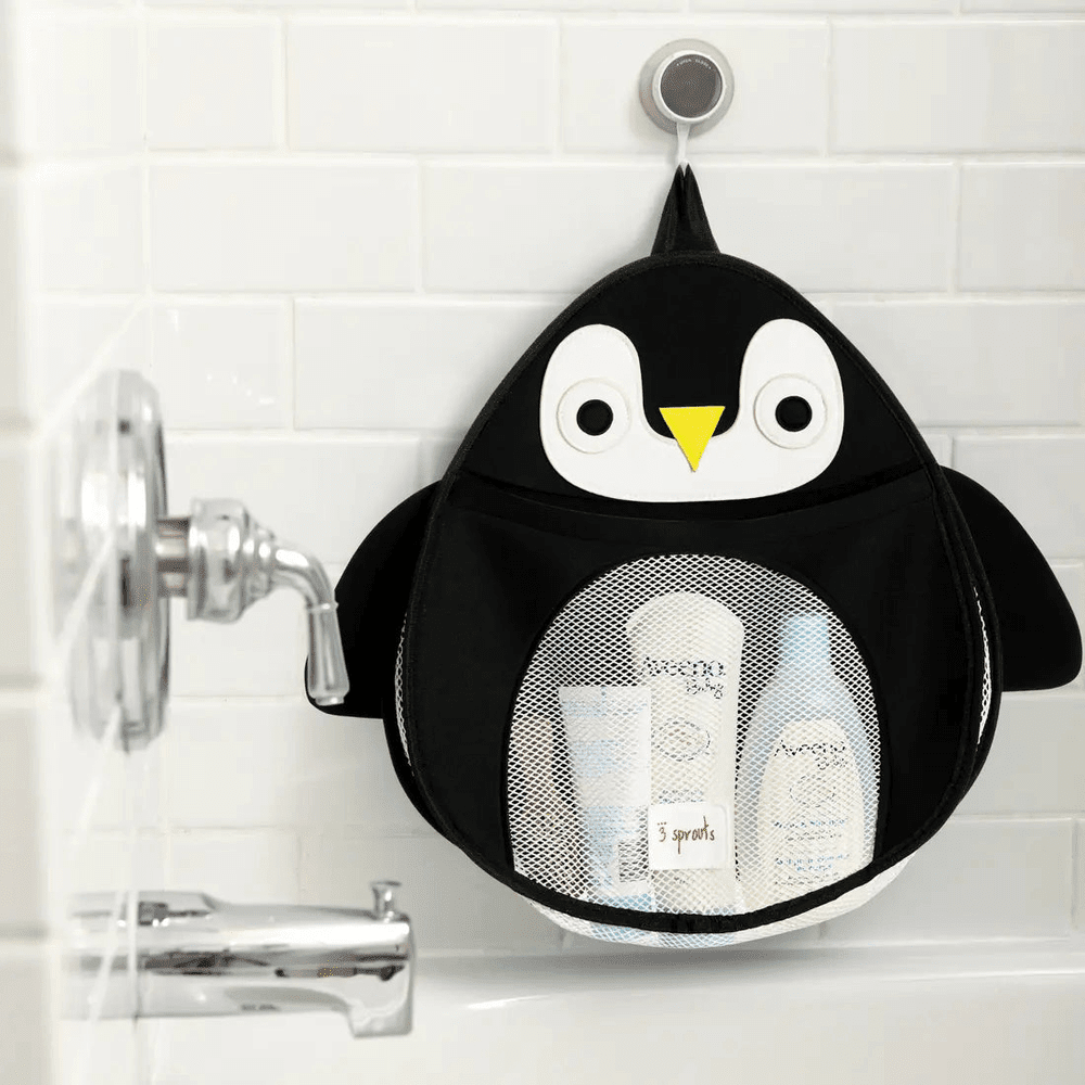 3 Sprouts Bath Storage bag in penguin design, hanging on a bathroom tile with mesh pockets holding toiletries.