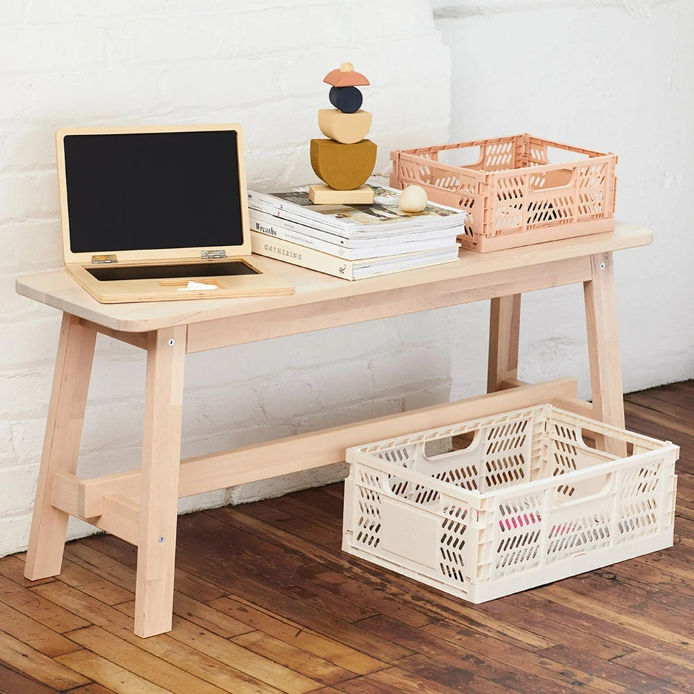 3 Sprouts Modern Folding Crate Clay storage crate, beige, on a wooden desk with a pink crate nearby