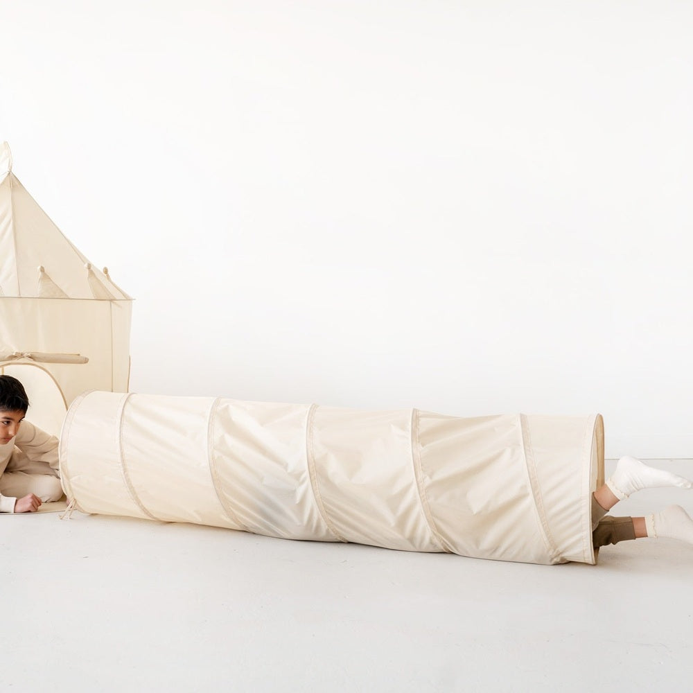 3 Sprouts recycled fabric play tunnel, beige, with a child peeking out at the end
