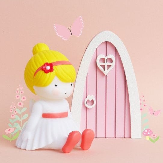 A Little Lovely Company Little Light Fairy figure with yellow hair in a white dress beside a pink arched night light