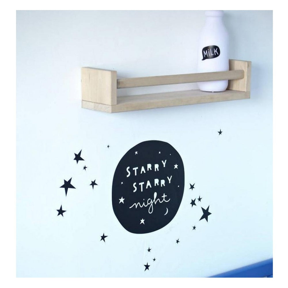 A Little Lovely Company Mini Milk Light in white on a light blue wall with star decals above a wooden shelf