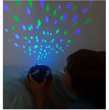 A Little Lovely Company Projector Night Light projecting blue-green starry ceiling; child holds the blue base.