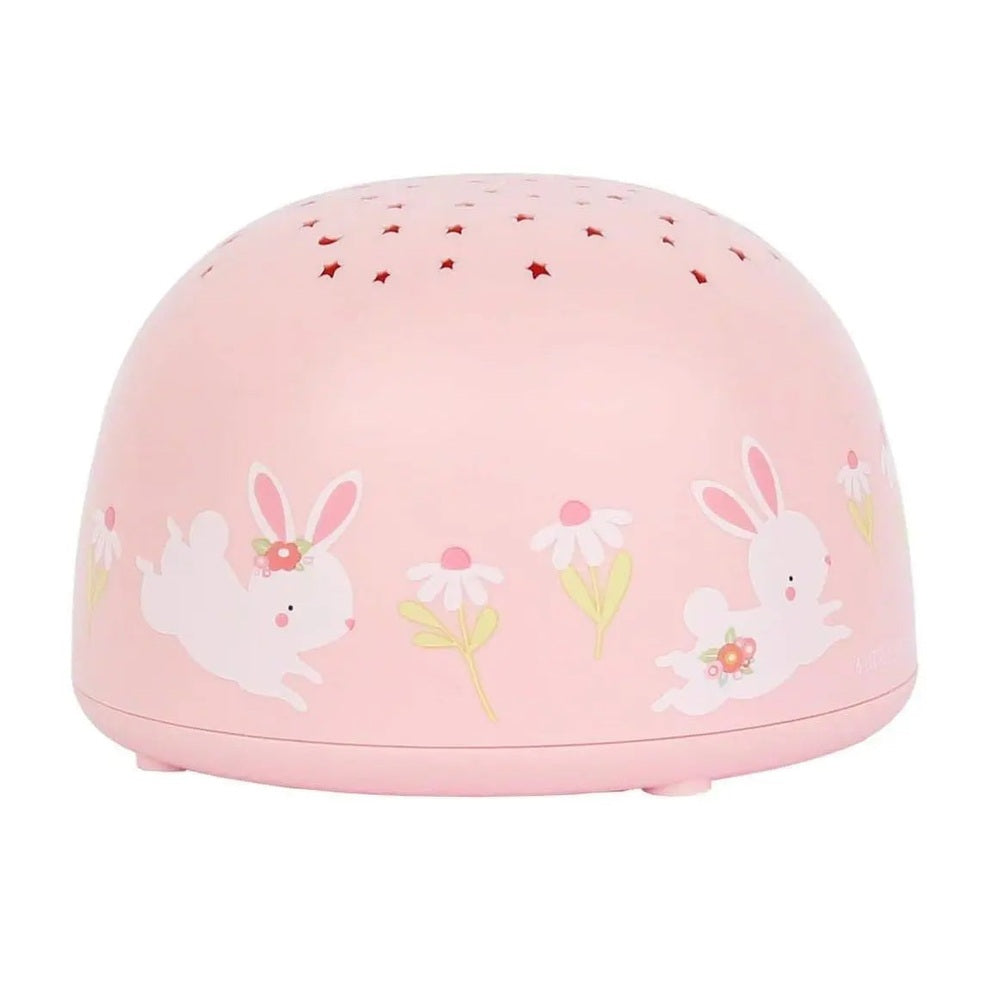 A Little Lovely Company Projector Night Light in pink with bunny and daisies decals, projecting star patterns from the perforated top.