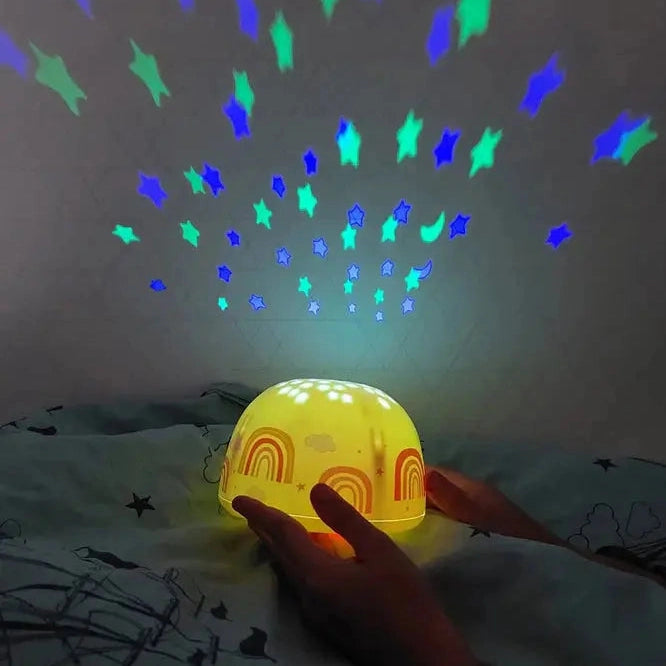 A Little Lovely Company Projector Night Light, yellow dome projecting blue and green stars and moons on ceiling.
