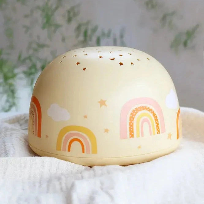 A Little Lovely Company Projector Night Light, cream dome with pastel rainbows and star perforations that glow softly.