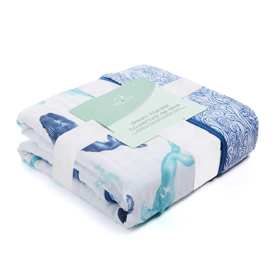 Aden+Anais Classic Dream Blanket, white with blue ocean print, neatly folded to show soft cotton swaddle comfort.