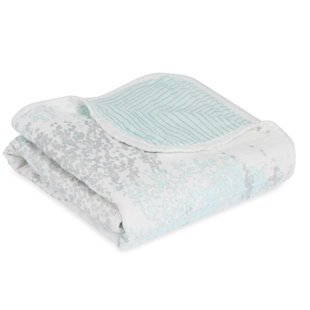 Aden+Anais Silky Soft Dream Blanket Met Skylight Birch with pale blue botanical print, neatly folded for cozy moments.