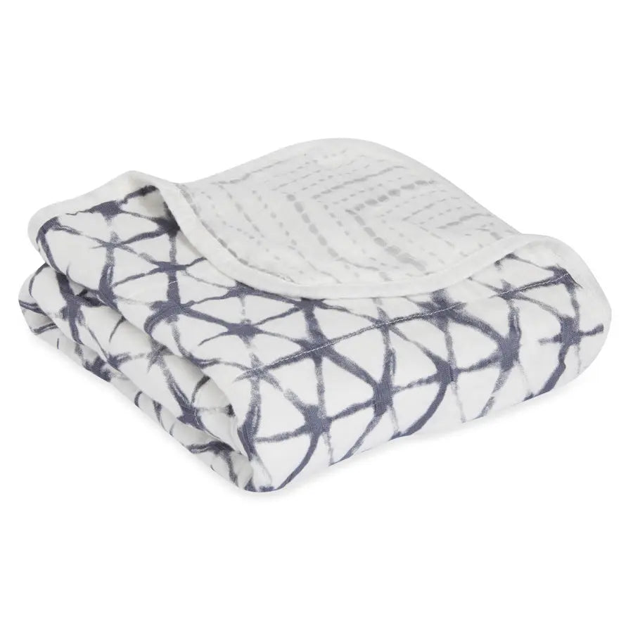 Aden+Anais Silky Stroller Blanket folded, white plush with navy geometric print—soft, cozy.