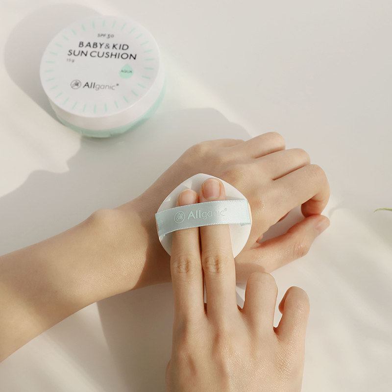 Allganic Baby & Kid Sun Cushion Aqua SPF30+ sunscreen applied to hand with round applicator pad