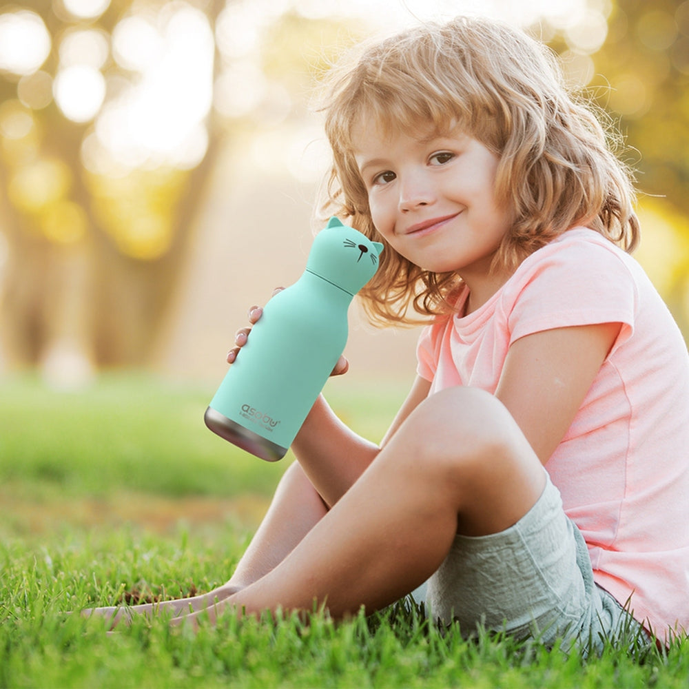 Child outdoors holding the ASOBU Bestie Animal 16oz Cat stainless steel bottle, teal, ready for hydration.