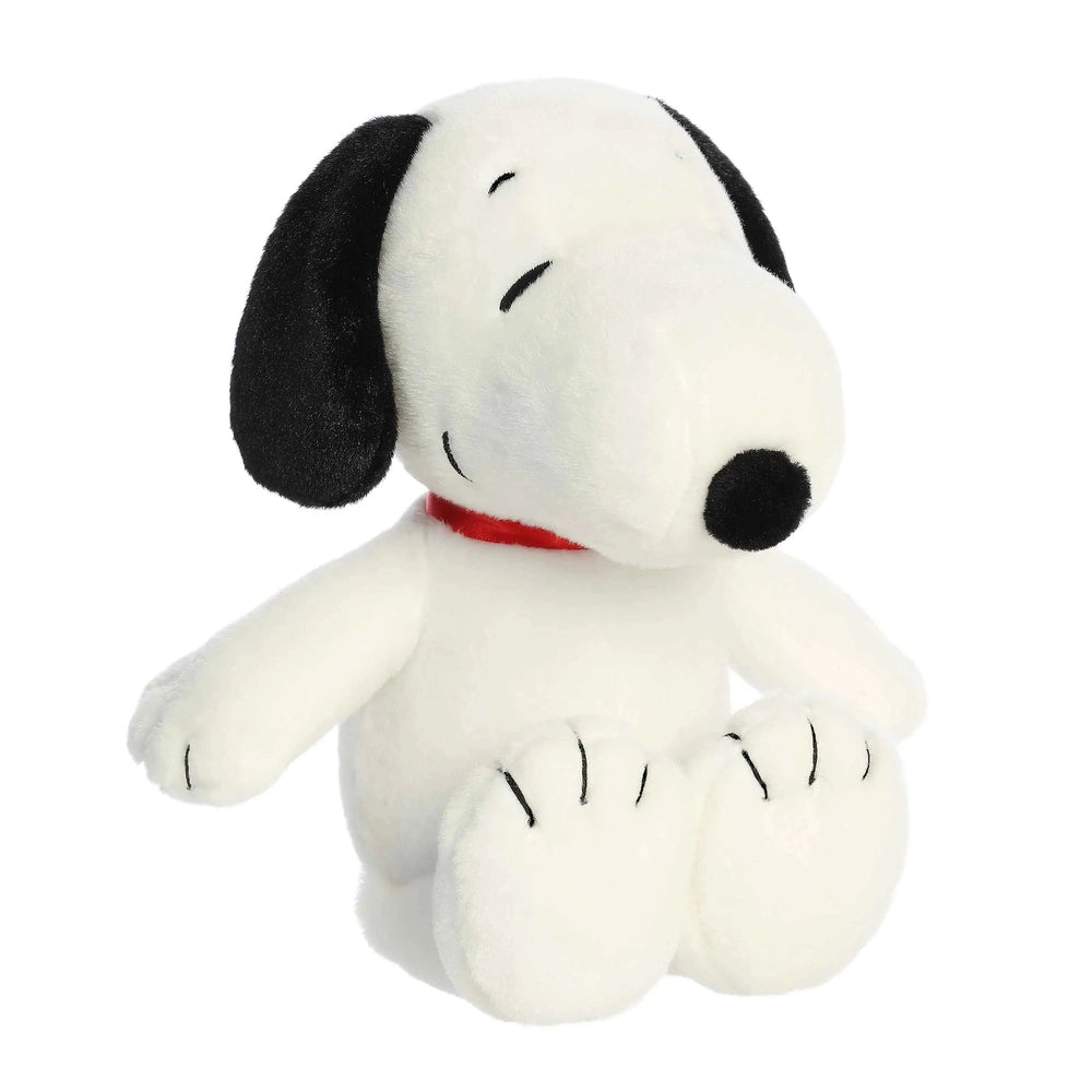 Snoopy 8-inch plush stuffed animal by Aurora, white with black ears and red collar, sitting with front paws forward.