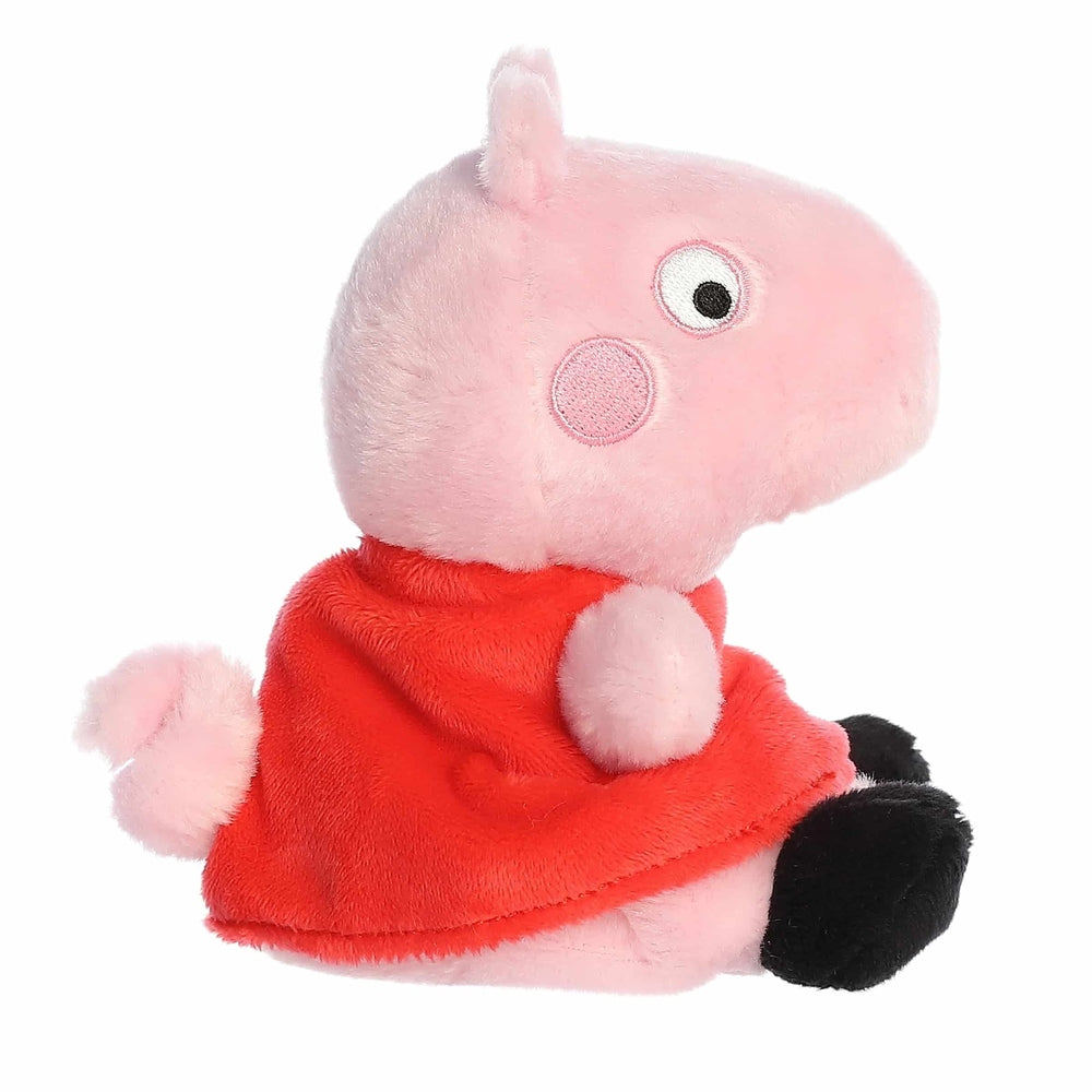 Aurora Peppa Pig Palm Pal plush toy, pink stuffed animal in a red dress with black feet.