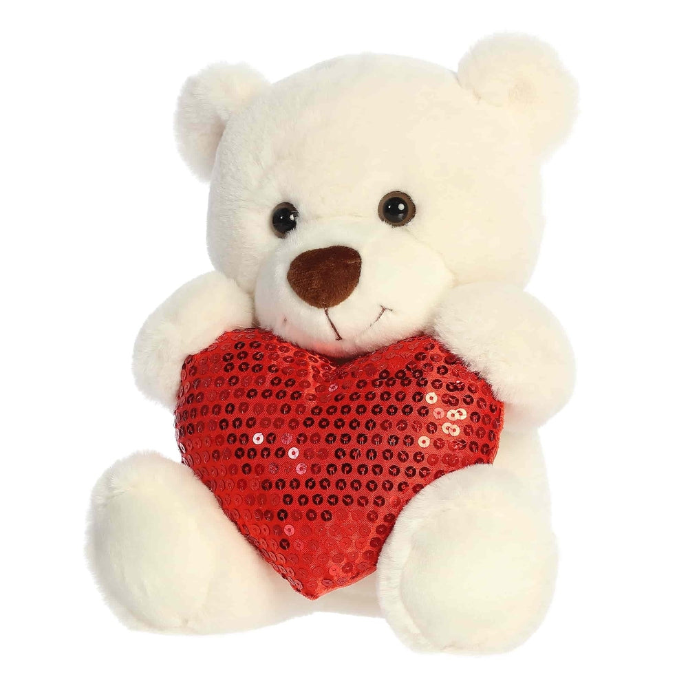 White plush teddy bear holding a red sequined heart