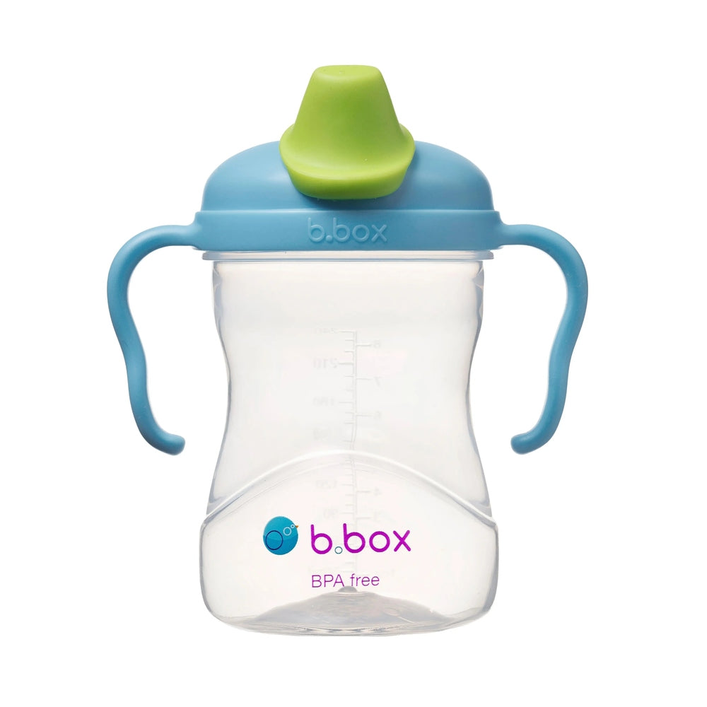 B.Box Spout Cup, blue handles and green spout, clear BPA-free bottle with logo; child grips the handles.