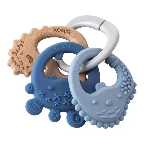 B.Box Trio Teether: set of 3 silicone teethers in blue and natural wood, interlinked for easy gripping.