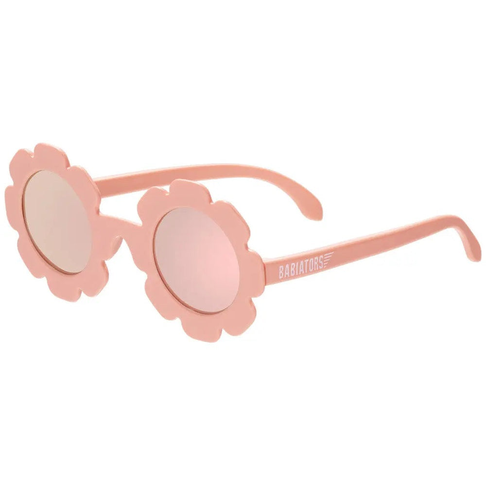 Babiators Flowers Shape Polarized Sunglasses Peachy Pink, two flower-frame kids' sunglasses lying flat on white surface with brand on arm