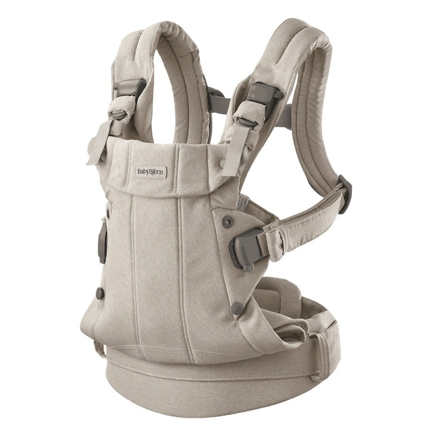 BabyBjörn Harmony baby carrier in beige with padded shoulder straps, waist belt, and adjustable buckles.