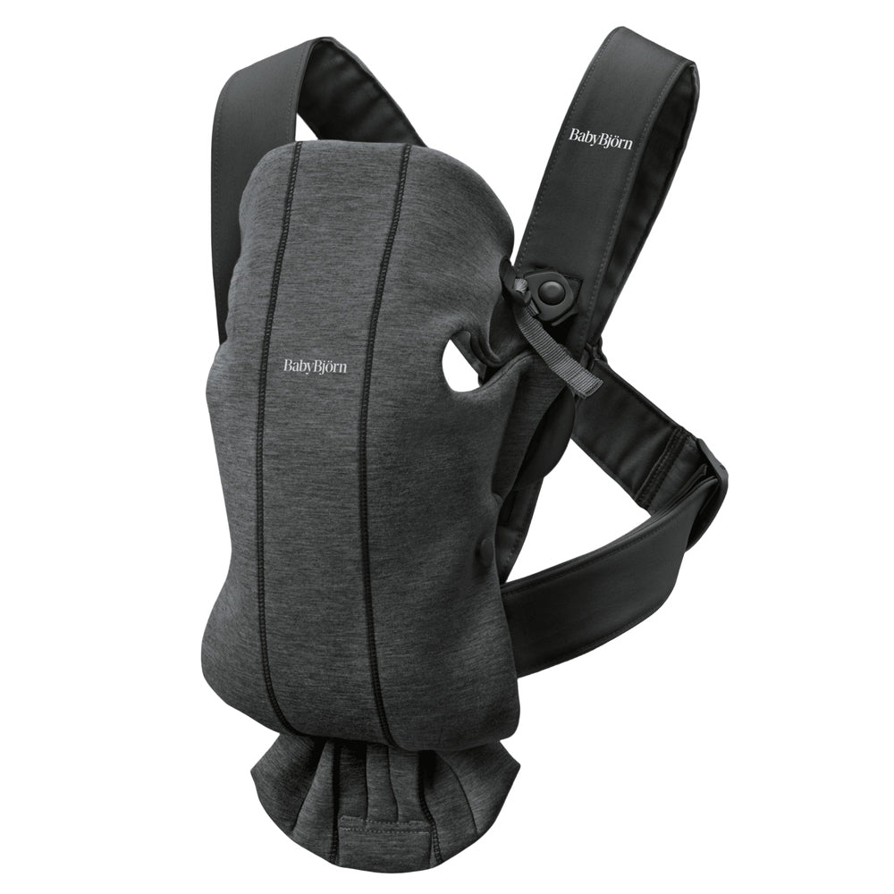 BabyBjörn Baby Carrier Mini in dark gray, with padded black straps buckled at the shoulders to support infant.