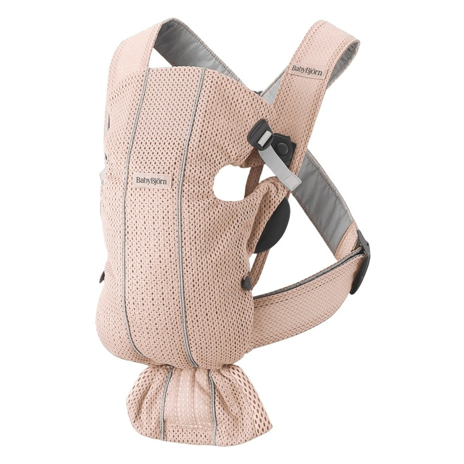 BabyBjörn Baby Carrier Mini in light-pink mesh with breathable holes and adjustable straps—buckled waist belt shown.