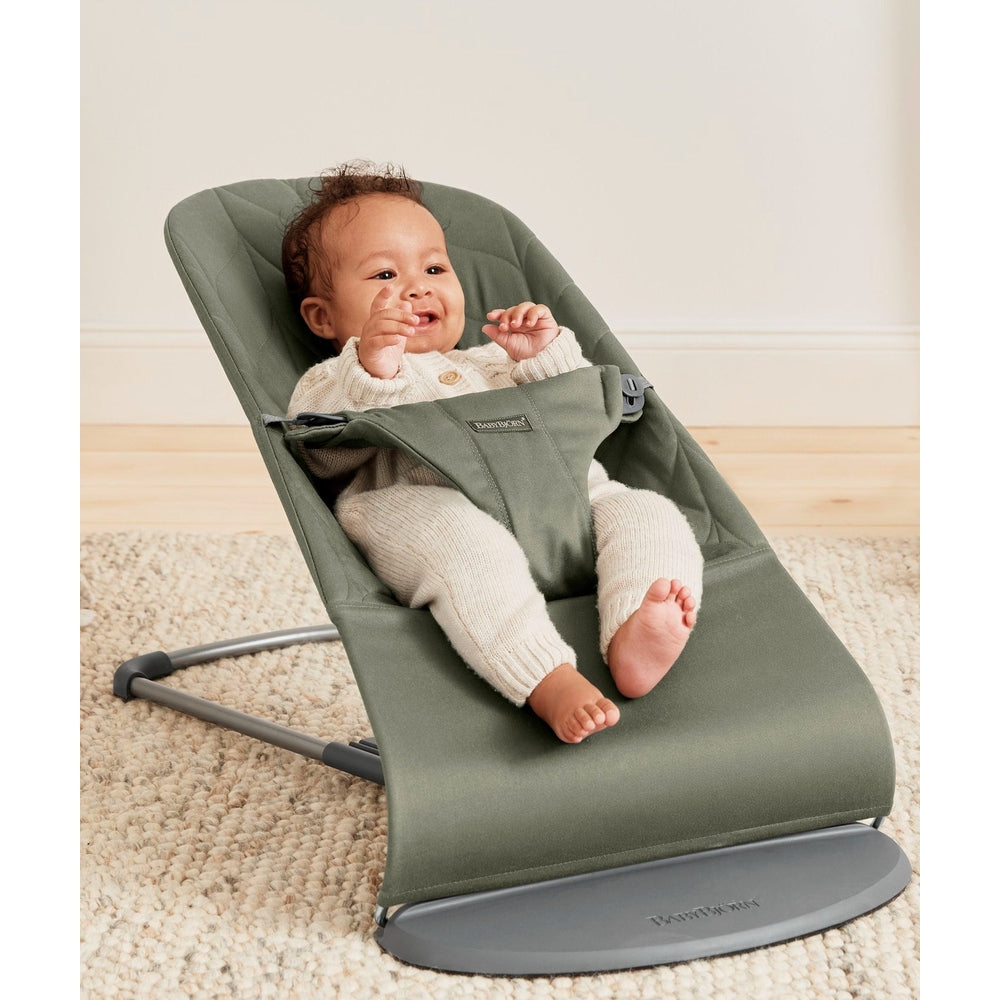 BabyBjörn Bouncer Bliss in sage green: baby smiles while gently bouncing in the soft, ergonomic seat.