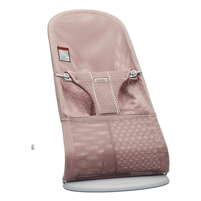 BabyBjörn Bouncer Bliss in rose-gold mesh rests on a white circular stand, showcasing breathable mesh and ergonomic seat.