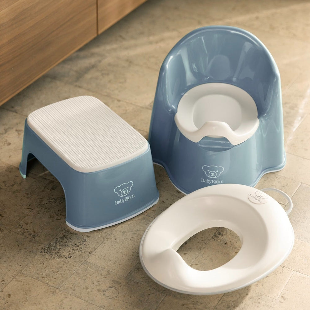 BabyBjörn Toilet Trainer three-piece blue set with textured step stool and white potty seat, ready for toddler use.
