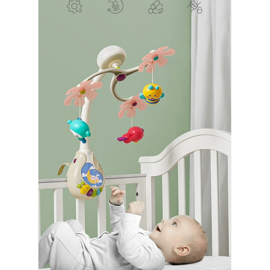 BC Babycare 3-In-1 Mobile over white crib with pastel pink flower arms and three colorful hanging toys