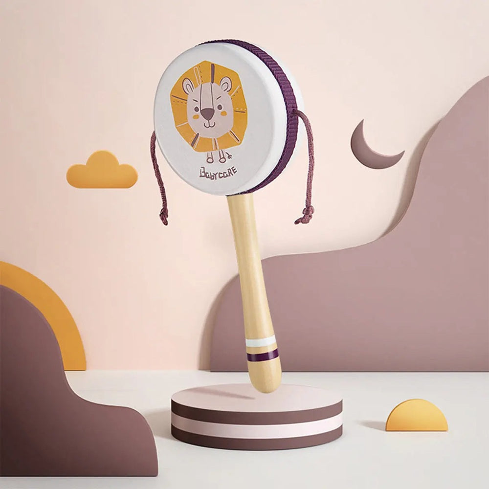BC Babycare Baby Rattle Drum in light wood with purple cord, lion design, standing upright on a round base.