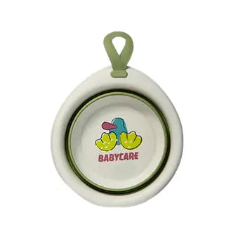 Bc Babycare Foldable Baby Washbasin, white with green trim and logo, hanging by loop for easy bath time.