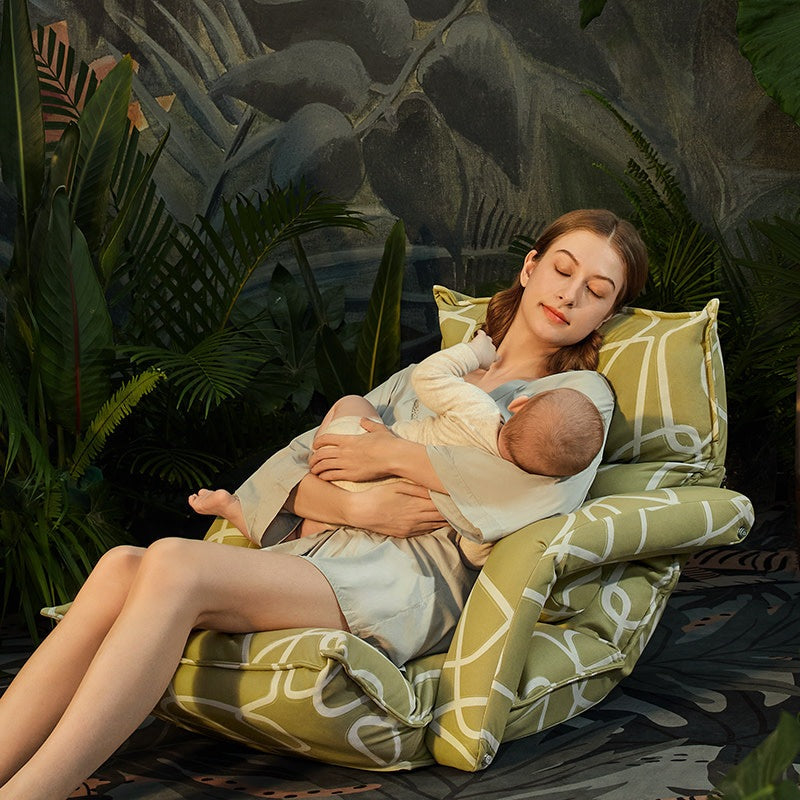 Bc Babycare latex-stuffed adjustable nursing chair in green geometric upholstery, mother nursing baby