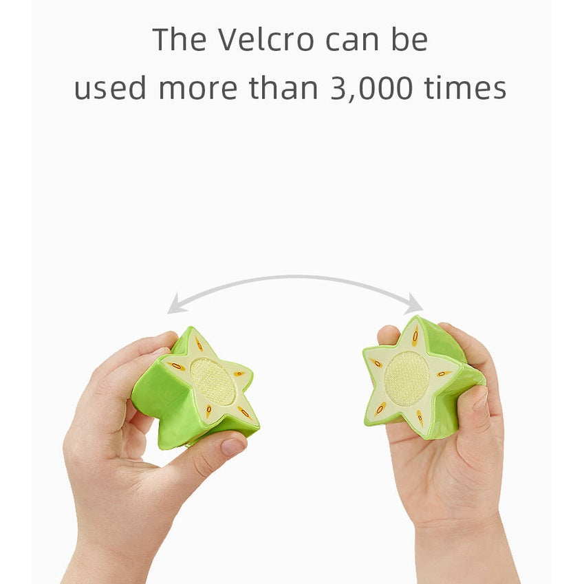 BC Babycare Little Cooker toy set fruit and veg, star-shaped green pieces held in hands.