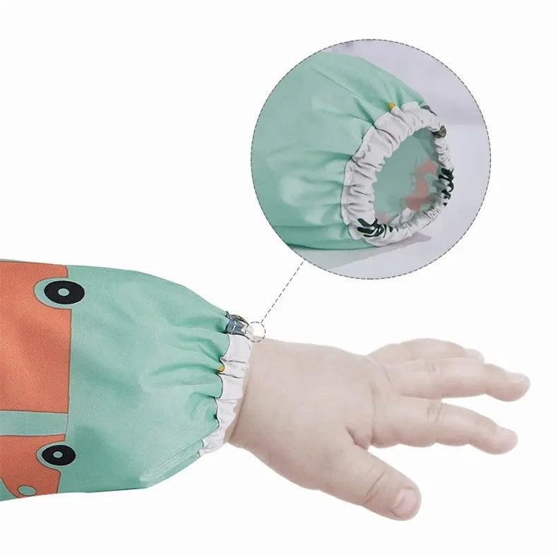 BC Babycare Long Sleeve Bib, mint green with white elastic cuffs, shown snug around a baby's wrist to catch spills during feeding.