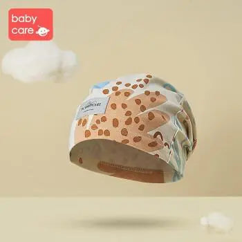 BC Babycare Maternity Hat in giraffe-print fabric floats in a soft sky scene, highlighting breathable comfort for new moms.