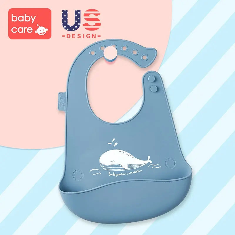 BC Babycare Silicone Adjustable Bib in blue with whale graphic; neckband shows adjustable holes and built-in food catcher.