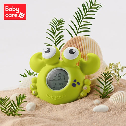 BC Babycare Smart Bath Thermometer crab-shaped in bright green with digital display on a sandy beach scene