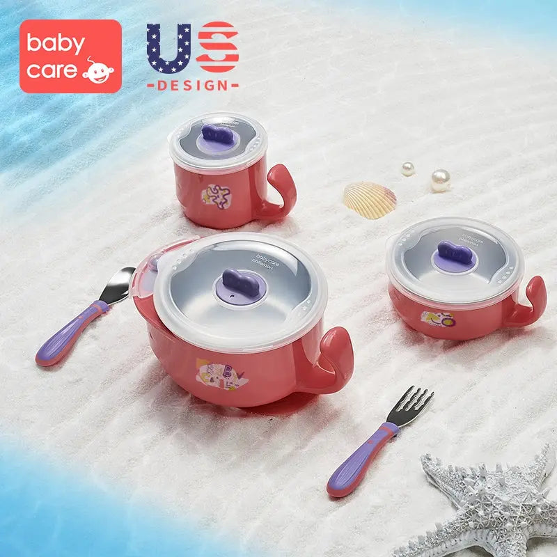 Bc Babycare Stainless Steel Feeding Set 5Pcs: pink pots with purple lids and utensils laid out on sandy beach.