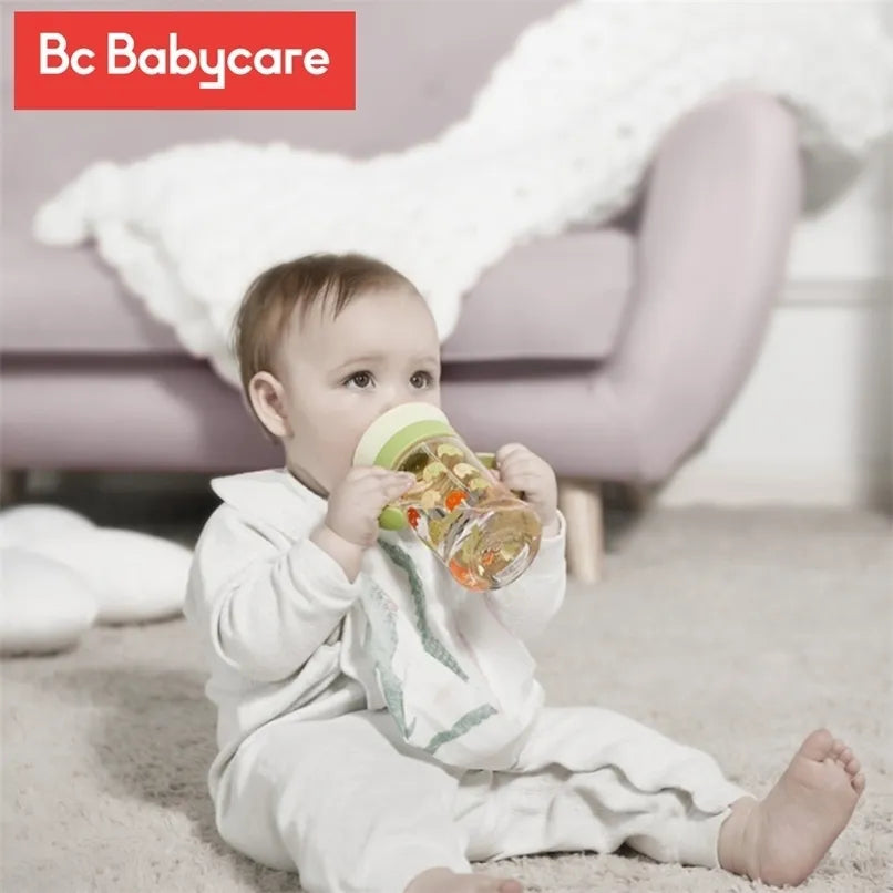 Bc Babycare Training Cup 260 ml with green lid, held by a baby indoors.