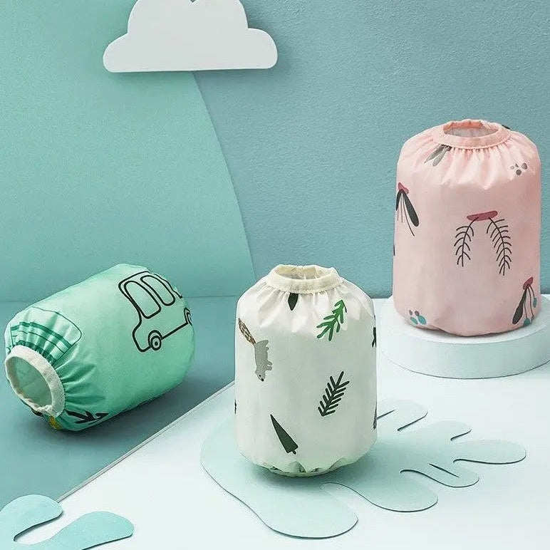 Bc Babycare Waterproof Arm Sleeve three-pack in mint, white-leaf, pink print displayed on a pastel play setup.