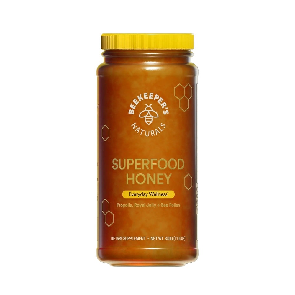 Beekeeper's Naturals Superfood Honey 330g jar with yellow cap, amber honey visible.