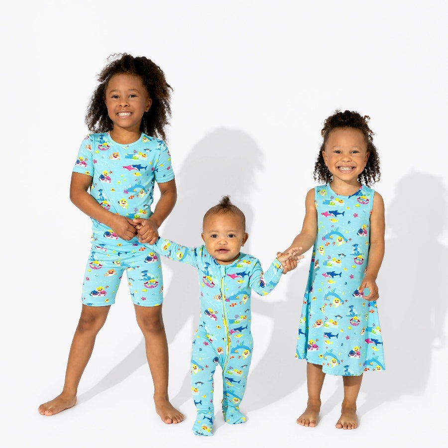 Bellabu Bear Bamboo Convertible Footie Baby Shark sleepwear; three kids in aqua shark-print outfits, with the baby in the center holding hands.