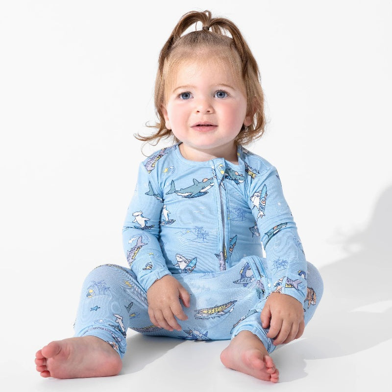 Bellabu Bear Bamboo Convertible Footie Shark School blue sleepsuit with front zipper, worn by a seated toddler.