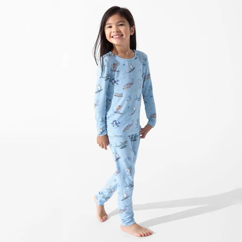 Bellabu Bear Bamboo Kids Pajamas Shark School set in light blue; girl wearing matching long-sleeve top and pants with sharks.