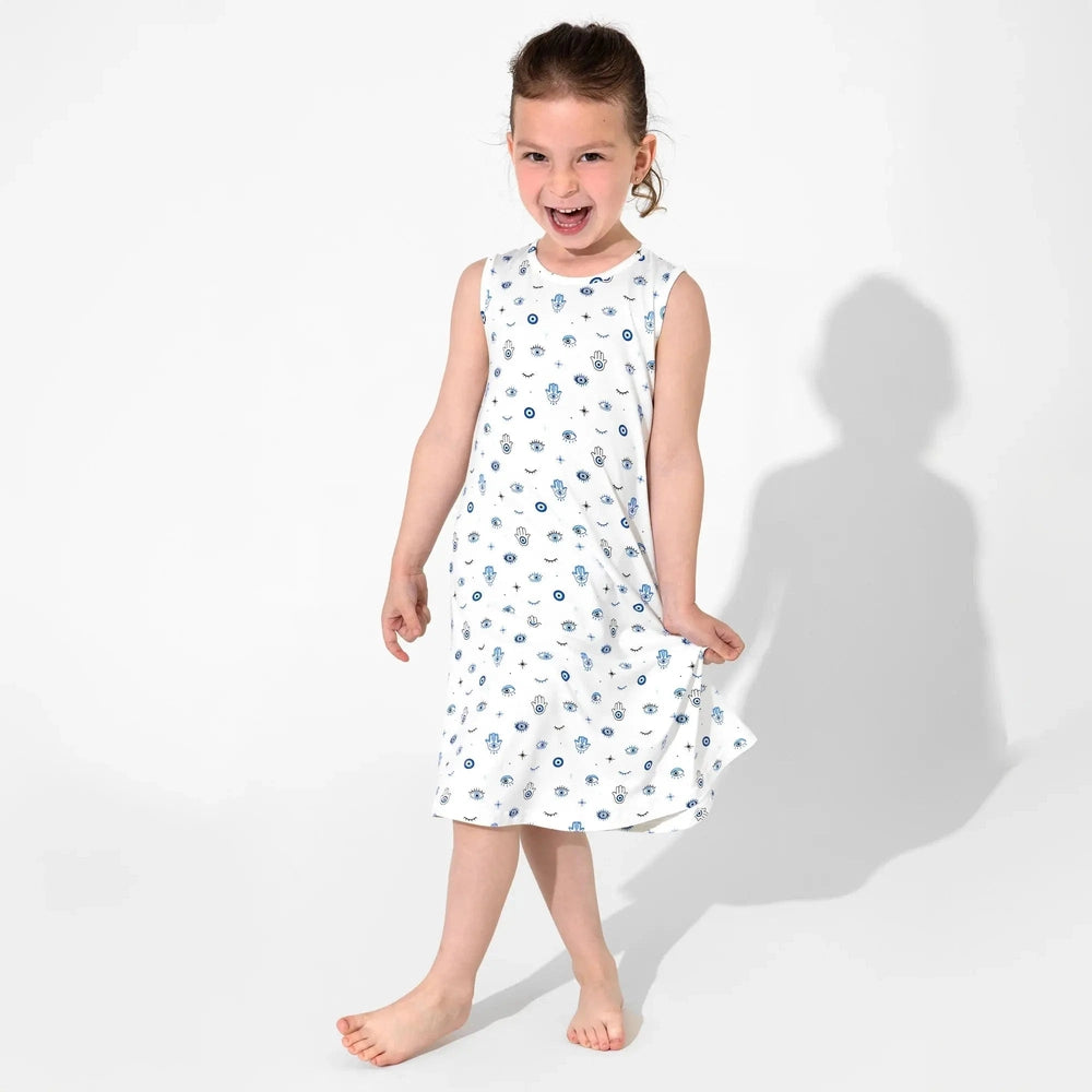 Bellabu Bear The Eye Bamboo Girls Sleeveless Dress in white with blue eye print; girl happily walks barefoot, showing breathable, flowy fabric.