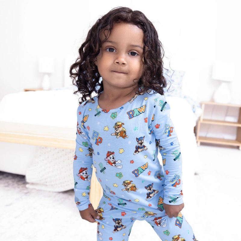 Bellabu Bear Varsity Blue Bamboo Kids Pajamas Paw Patrol worn by a child standing in a cozy bedroom